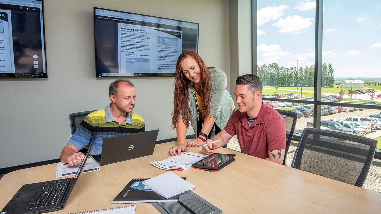 three people in a boardroom